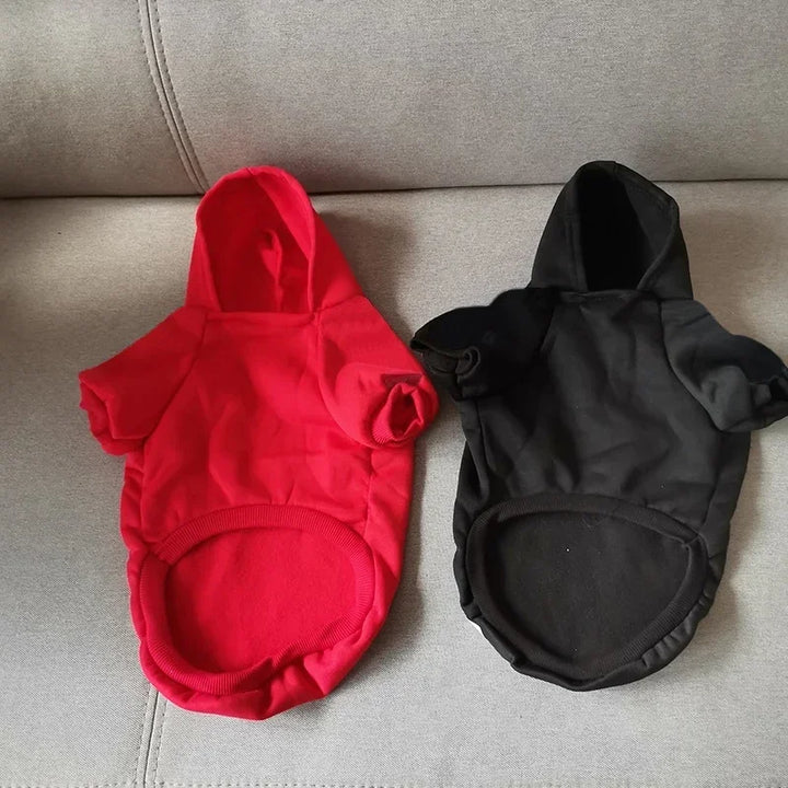 Pets-Shop: Two pet hoodies, one red and one black, displayed on a grey sofa. Shopets-Amazon.