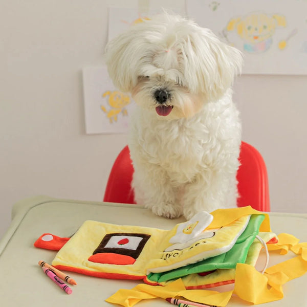 Pets-Shop A fluffy white dog sitting on a red chair with a colorful book and crayons on a table. Shopets-Amazon.